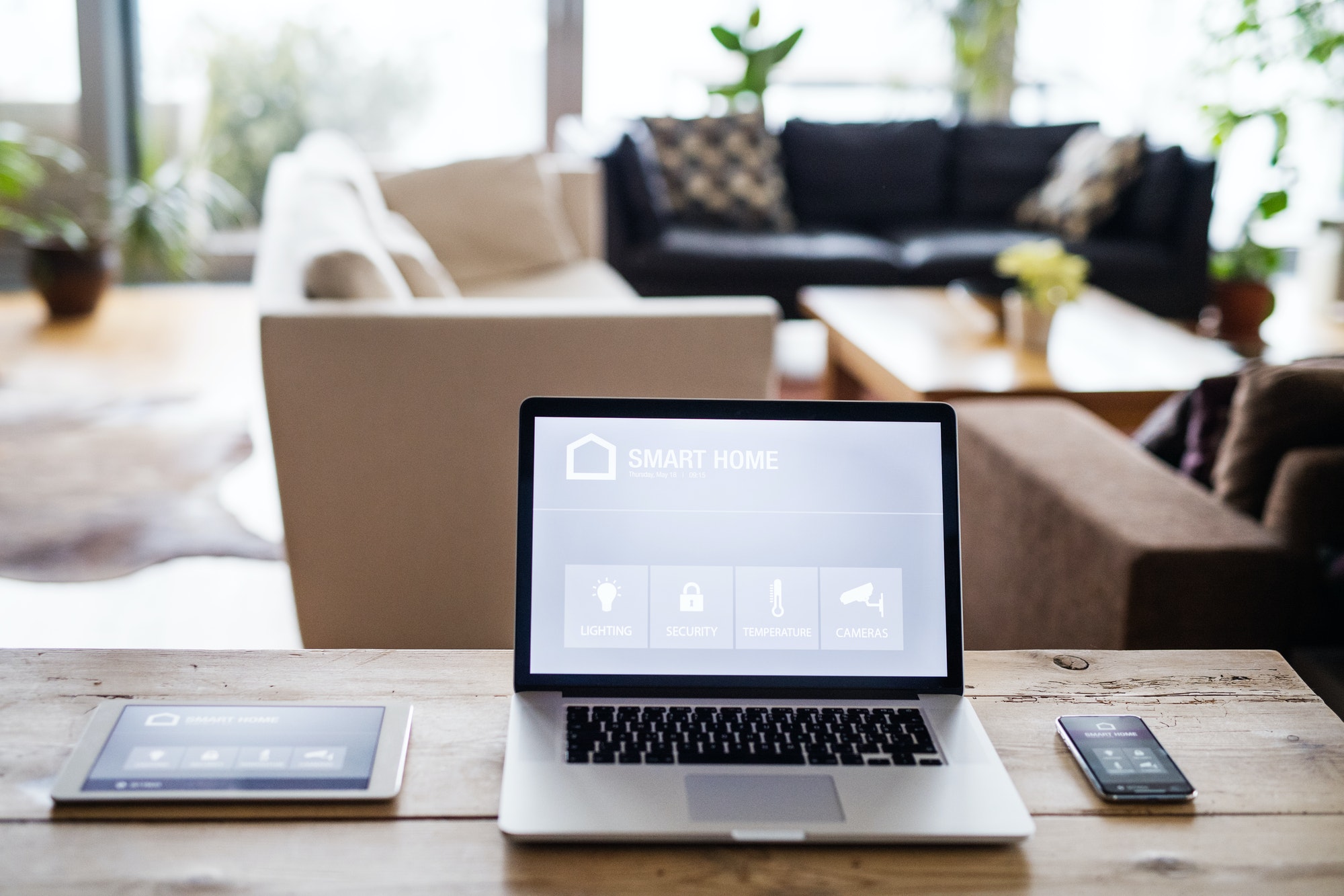 A laptop, tablet and telephone with smart home screen.